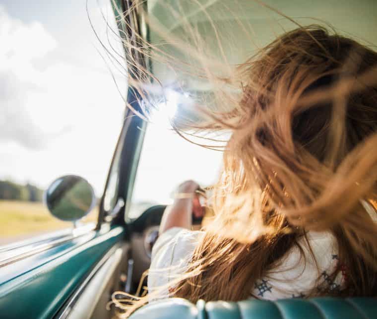 frau_am_steuer Frau am Steuer und der Fahrtwind bläst ihr ins Haar