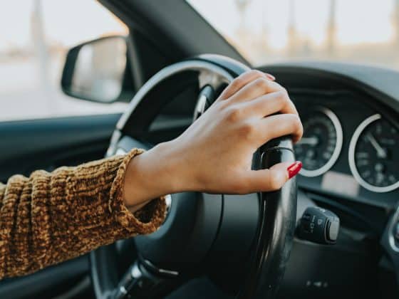 Frau_Lenkrad Frau im Auto mit Lenkrad in der Hand und roten Fingernägeln