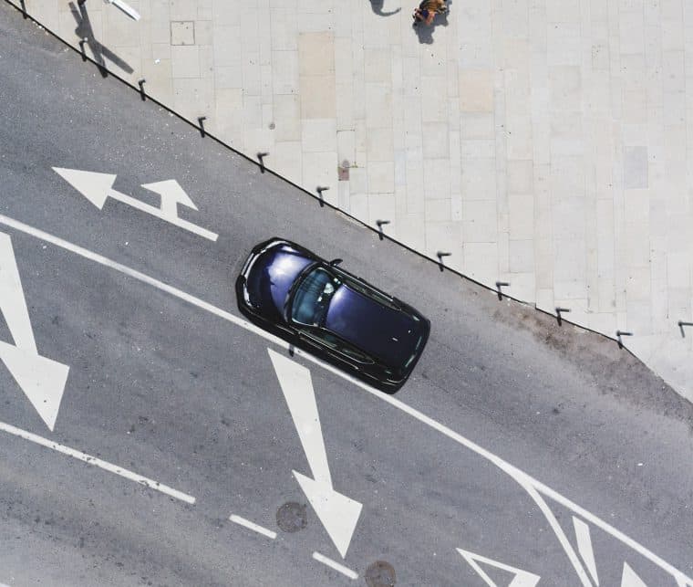 auto_strassenspuren Auto auf Fahrbahn mit Straßenbodenmarkierungen
