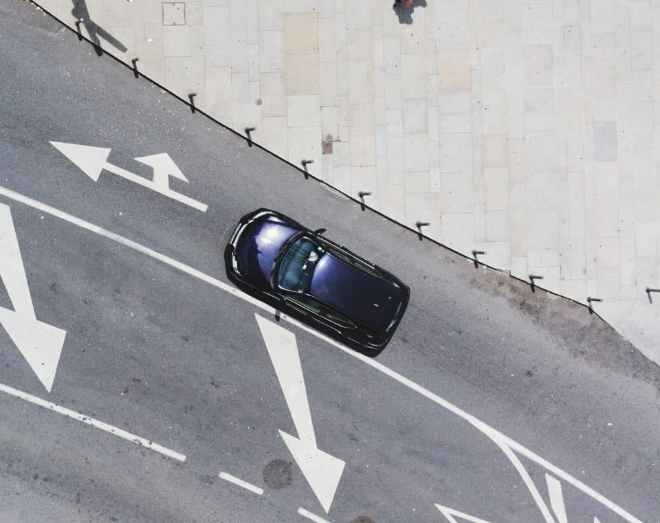 auto_strassenspuren Auto auf Fahrbahn mit Straßenbodenmarkierungen